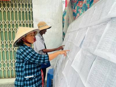 Người dân đặc khu Kiên Hải đến khu vực bỏ phiếu bầu cử kiểm tra danh sách cử tri. Ảnh: Văn Sĩ - TTXVN 