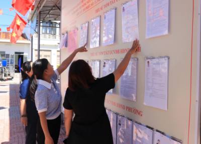 Người dân xem thông tin người ứng cử được niêm yết công khai tại phường Cam Ranh. Ảnh: Phan Sáu - TTXVN 