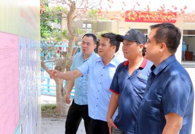 Người dân ở xã Cà Ná theo dõi sát sao danh sách niêm yết ứng cử viên Đại biểu Quốc hội khóa XVI và Đại biểu HĐND các cấp tại tổ bầu cử số 6. Ảnh: Công Thử - TTXVN