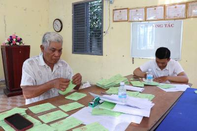 Ông Thạch Ly Kô (trái), Bí thư Chi bộ ấp Hòa Lạc C, xã Song Lộc, đang chuẩn bị phiếu cử tri cho người dân. Ảnh: Thanh Hòa- TTXVN