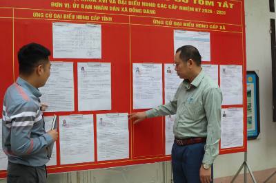 Đảng viên Chi bộ thôn Nam Quan, xã biên giới Đồng Đăng, tỉnh Lạng Sơn tuyên truyền hướng dẫn bầu cử tại nơi niêm yết danh sách những người ứng cử. Ảnh: Quang Duy - TTXVN