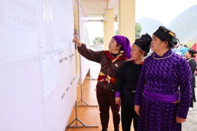 Cử tri xem danh sách ứng cử viên được niêm yết công khai tại nhà văn hóa thôn Nà Chang, xã Quản Bạ. Ảnh: Minh Đức – TTXVN