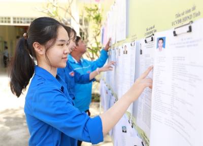 Những cử tri lần đầu tham gia bỏ biểu bầu cử tìm hiểu tiểu sử tóm tắt người ứng cử Quốc hội và HĐND các cấp. Ảnh: Xuân Triệu - TTXVN