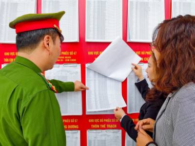 Cử tri xã Sóc Sơn tìm hiểu thông tin về các ứng cử viên được niêm yết công khai tại điểm bỏ phiếu. Ảnh: Trung Nguyên - TTXVN