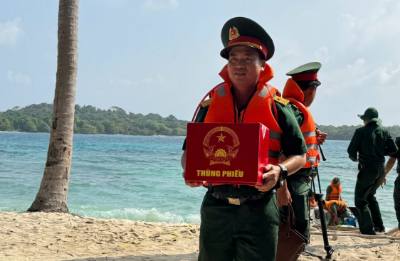 Le bureau de vote n°5 apporte une urne supplémentaire sur l'île de Hon Tu pour que les officiers et les soldats puissent voter.  Photo VNA : Văn Sĩ