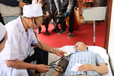 Xử lý tình huống cử tri bị ngất trong quá trình bỏ phiếu tại điểm vận hành bầu cử mẫu ở số 58, Nhà văn hóa tổ dân phố Bình Minh, phường Hạc Thành. Ảnh: Khiếu Thị Tư - TTXVN 