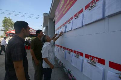 Cử tri xã Vị Thanh 1, thành phố Cần Thơ kiểm tra danh sách niêm yết tên của mình để đi bầu cử sắp tới. Ảnh: Duy Khương – TTXVN