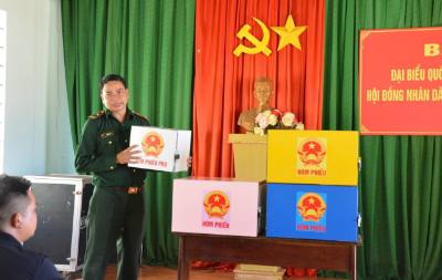 Lực lượng biên phòng phối hợp với chính quyền địa phương hướng dẫn người dân quy trình bỏ phiếu bầu cử đúng theo quy định. Ảnh: Hồng Điệp - TTXVN