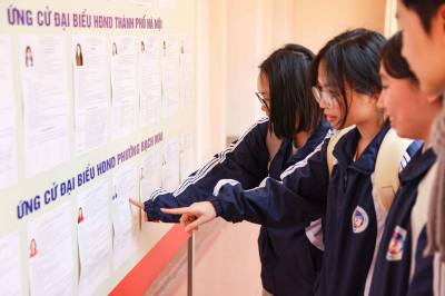 Sinh viên xem danh sách người ứng cử đại biểu Quốc hội khóa XVI và đại biểu HĐND các cấp tại Khu vực bỏ phiếu số 19 – Đại học Kinh tế Quốc dân. Ảnh: Thanh Tùng – TTXVN