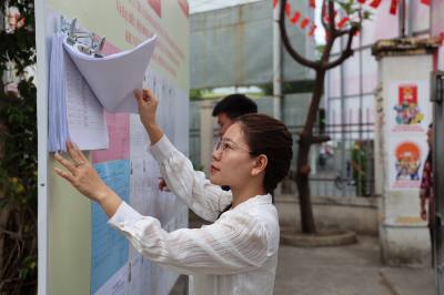 Người dân Nha Trang theo dõi thông tin tuyên truyền về bầu cử được niêm yết tại khu dân cư. Ảnh Đặng Tuấn - TTXVN