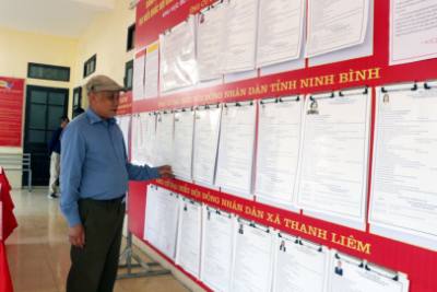 Cử tri xã Thanh Liêm tìm hiểu tiểu sử các ứng cử viên đại biểu Quốc hội và đại biểu HĐND các cấp. Ảnh: Nguyễn Chinh - TTXVN