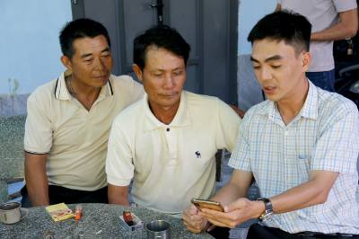 Cán bộ xã Tiến Thành (Lâm Đồng) tuyên truyền thông tin về ngày bầu cử cho ngư dân. Ảnh: Nguyễn Thanh - TTXVN