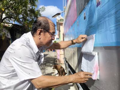 Người dân ấp An Thuận, xã Tân Thủy (Vĩnh Long) xem bảng niêm yết danh sách cử tri. Ảnh: Huỳnh Phúc Hậu - TTXVN