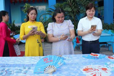 Đông đảo người dân trải nghiệm sản phẩm móc khóa QR Code tuyên truyền bầu cử thông minh tại phường Tân Sơn Hòa. Ảnh: Thanh Vũ-TTXVN