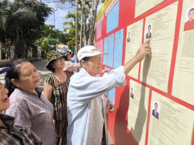 Giáo dân ấp Vĩnh Bắc, xã Vĩnh Thành (Vĩnh Long) tìm hiểu thông tin về các đại biểu ứng cử. Ảnh: Huỳnh Phúc Hậu - TTXVN