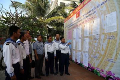 Cử tri tìm hiểu lần cuối tiểu sử các đại biểu ứng cử trước khi viết phiếu bầu. Ảnh: TTXVN phát