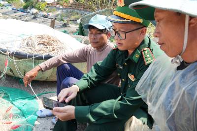 Bộ đội Biên phòng và ngư dân tại đảo Cù Lao Chàm (xã Tân Hiệp, thành phố Đà Nẵng) theo dõi thông tin về bầu cử trên điện thoại. Ảnh: Anh Dũng - TTXVN
