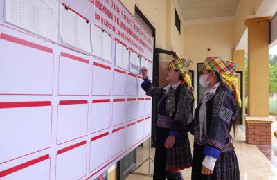 Cử tri xã Púng Luông xem danh sách cử tri được niêm yết công khai tại khu vực bỏ phiếu. Ảnh: Tuấn Anh - TTXVN