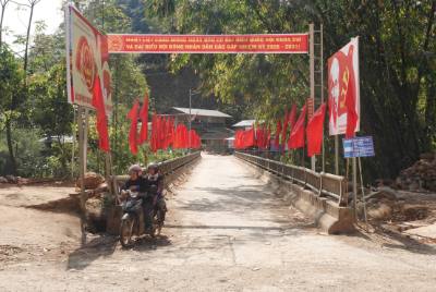 Con đường dẫn qua cầu vào xã Lao Chải được xã trang trí dày đặc cờ đỏ và băng rôn tuyên truyền chào mừng ngày bầu cử Quốc hội và Hội đồng Nhân dân nhiệm kỳ 2026–2031. Ảnh: Tuấn Anh - TTXVN