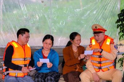Cảnh sát đường thủy Hà Nội hỗ trợ đưa thẻ cử tri đến với cư dân xóm chài bến đò Văn Đức, xã Bát Tràng (Hà Nội). Ảnh: TTXVN phát