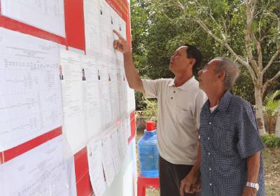 Người dân xã Đất Mũi tìm hiểu danh sách ứng cử viên. Ảnh: Tuấn Phi – TTXVN 