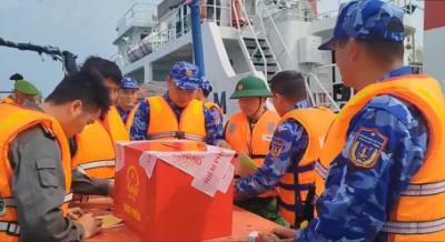 Ban chỉ đạo công tác bầu cử đặc khu Bạch Long Vĩ di chuyển hòm phiếu phụ ra tàu nơi lực lượng chấp pháp đang làm nhiệm vụ trên biển để cử tri bỏ phiếu. Ảnh: TTXVN phát