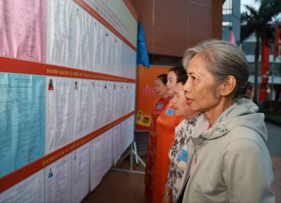 Cử tri phường Nha Trang theo dõi tiểu sử người ứng cử. Ảnh: Xuân Triệu - TTXVN