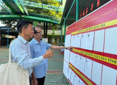 Các cử tri tìm hiểu về các ứng cử viên tại khu vực bỏ phiếu số 19, tổ 17, phường Long Bình. Ảnh: Sỹ Tuyên - TTXVN