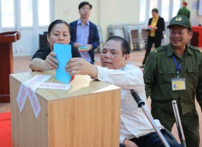 Thương binh nặng đang điều dưỡng tại Trung tâm Điều dưỡng thương binh Thuận Thành cùng nhân dân phường Ninh Xá, tỉnh Bắc Ninh tham gia bầu cử. Ảnh: Hoàng Hiếu - TTXVN