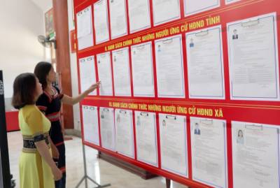 Người dân xã vùng biên Bờ Y tranh thủ xem lại tiểu sử các ứng cử viên trước khi lựa chọn để bầu. Ảnh: Cao Nguyên-TTXVN
