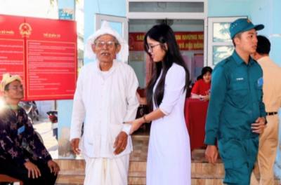 Cụ Dương Tình (83 tuổi, ở làng gốm truyền thống Bàu Trúc, xã Ninh Phước) cùng cháu nội hoàn thành sớm bỏ phiếu trong sáng sớm ngày bầu cử. Ảnh: Công Thử - TTXVN