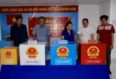 Các thành viên Tổ bầu cử số 36, phường Bình Đông, TP. Hồ Chí Minh tiến hành quy trình kiểm phiếu. Ảnh: Thanh Vũ – TTXVN